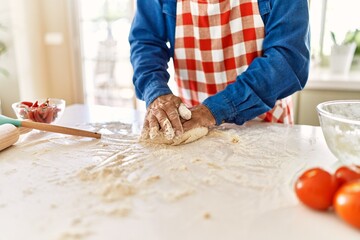 Poster - Senior man keading dough with hands at kitchen