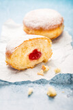 Fototapeta  - German donuts - berliner filled with strawberry jam with icing sugar