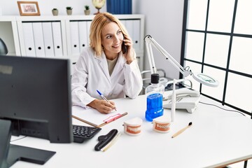 Sticker - Young blonde woman wearing dentist uniform speaking on the smartphone at dental clinic