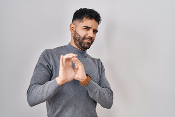 Poster - Hispanic man with beard standing over white background disgusted expression, displeased and fearful doing disgust face because aversion reaction.