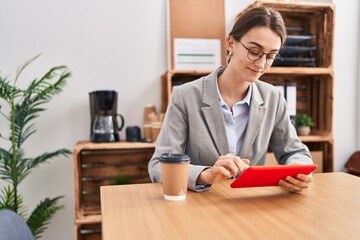 Poster - Young caucasian woman business worker using touchpad at office