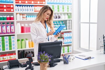 Sticker - Young beautiful hispanic woman pharmacist using touchpad and computer at pharmacy