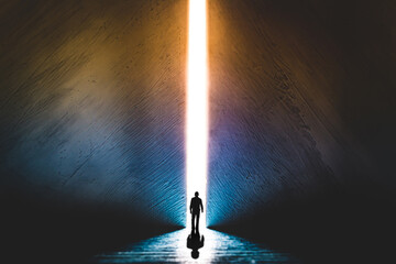 the silhouette of a man walking towards a bright light in the opened huge wall. a light in the end o