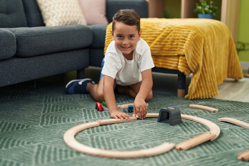 Sticker - Adorable hispanic toddler playing with car game sitting on floor at home