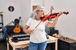 © Krakenimages.com - Middle age woman musician playing violin at music studio