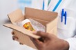African american woman pharmacist holding package with pills bottle at pharmacy