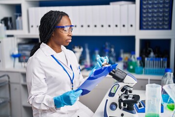 Canvas Print - African american woman wearing scientist uniform working laboratory