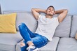 © Krakenimages.com - Young hispanic man relaxed with hands on head sitting on sofa at home