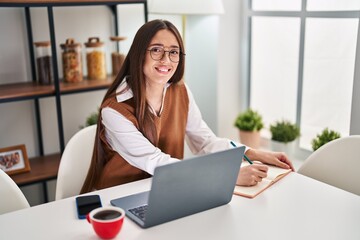 Sticker - Young beautiful hispanic woman writing on notebook sitting on table studying at home