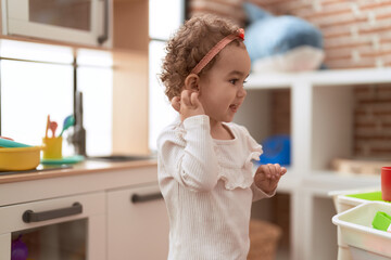 Wall Mural - Adorable caucasian girl standing with relaxed expression at kindergarten