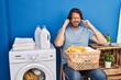 © Krakenimages.com - Handsome middle age man waiting for laundry covering ears with fingers with annoyed expression for the noise of loud music. deaf concept.