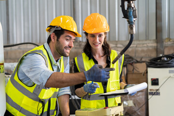 Aufkleber - Two male and female engineer checking and maintenance robot arm in the workshop. Team of technician worker working with control automatic robot arm system welding in the industry factory