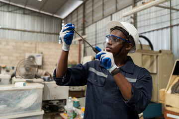 Aufkleber - African American male worker working and checking parts of lathe machine in the industry factory