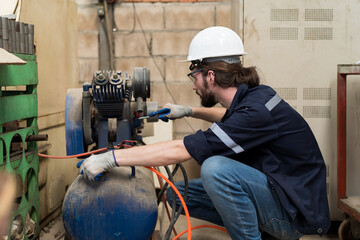 Aufkleber - Male engineer worker using air compressor in the industry factory. Male engineer worker checking or maintenance air compressor machine in the factory
