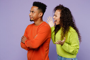 Young angry sad mad furious couple two friends family man woman of African American ethnicity wear casual clothes together scream spread hands abuse isolated on pastel plain light purple background.