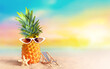 Pineapple with sunglasses on tropical beach background. Summer beach concept.