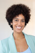 © KAMPUS - Portrait of smiling successful black woman with Afro hairstyle. Positive confident business lady in jacket against isolated background. Leader concept
