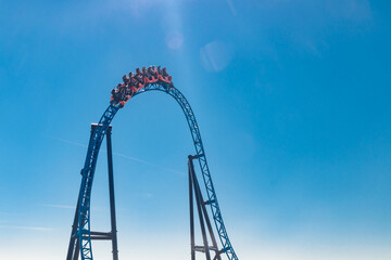 Ride roller coaster in blurred motion on sky background in amusement park