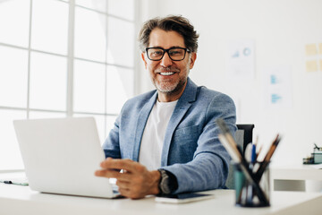 Wall Mural - Senior software developer working on a laptop in an office