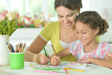 Canvas Print - little girl with mother drawing at the table at home