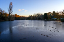 A Frozen Lake At Sunset. There Is Ice On The Surface Of The Lake In This Winter Scene. A Cold Winter's Day In Kelsey Park, Beckenham, Kent, UK.
