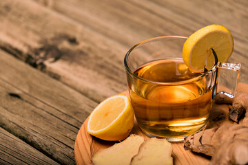 Hot ginger-infused cup on a white table with sliced ginger root in a bowl. Top view.