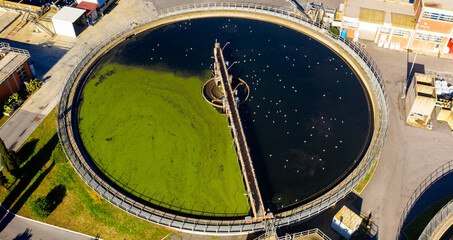 Wall Mural - Aerial view of the tanks of a sewage and water treatment plant enabling the discharge and re-use of waste water. It's a sustainable water recycling with treatment plant.