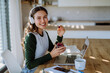 © Halfpoint - Young woman having distance education in her apartment.