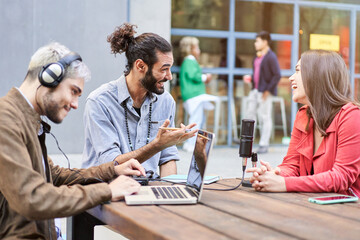 Young man interviewing a woman in a casual radio studio outdoors. High quality photo