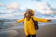 Happy tourist in a yellow jacket  enjoying sea landscape. Travelling, lifestyle, adventure.