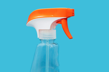 Plastic transparent spray bottle with detergent on a blue background. Detergent for cleaning and disinfecting rooms and washing windows or dishes with a spray function. The concept of cleanliness