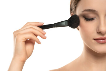 Poster - Woman using make-up brush, isolated on white background