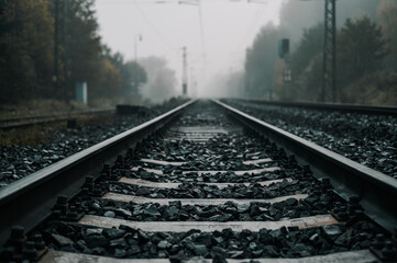 Railroad track rails in coutry landspace in autumn weather with foggy landscape. Industrial concept. Railroad travel, railway tourism.