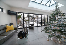 Bifold Doors And Skylight At Christmas / Xmas With Luxury Room, Christmas Tree And View To Garden With Snow.