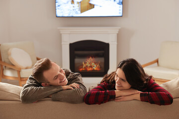 Sticker - Happy lovely couple spending time together near fireplace at home