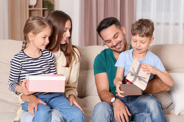 Sticker - Happy family presenting each other with gifts on sofa at home