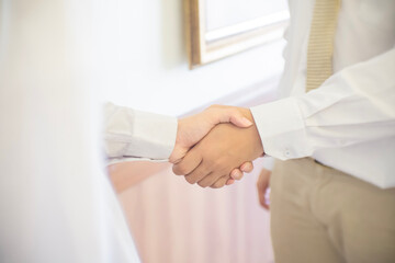 Wall Mural - Close up of two businessmen shake hands after a business deal in the office.