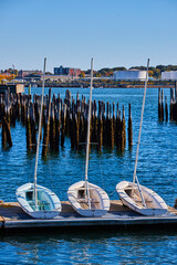 Wall Mural - Trio of three small boats on dock with old pilings in background