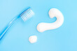 Toothbrush and question mark on blue background close-up, top view.