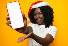 Beautiful African Woman Wearing Santa Hat With Blank Copyspace Screen On Phone