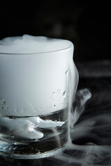 Wall Mural - Smoke in a glass of cool ice water