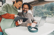 © simona - Modern couple of traveler enjoy work office inside camper van. Happy woman and man in modern job activity with freedom of motor home vehicle. Alternative vacation and lifestyle people. Travel rv