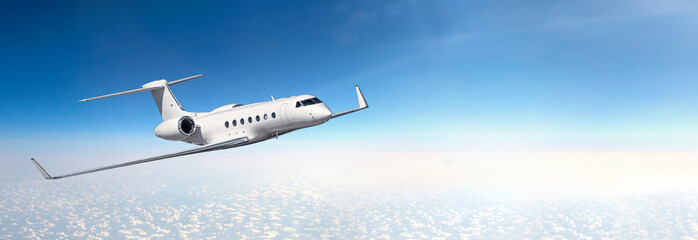 Wall Mural - A business plane flying at high altitude above the clouds