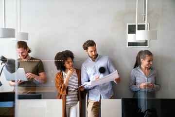 Group of young happy creative team, multicultural coworkers working in office together