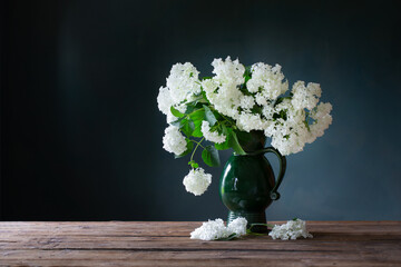 Wall Mural - white hydragea in vintage jug on wooden table on background dark wall