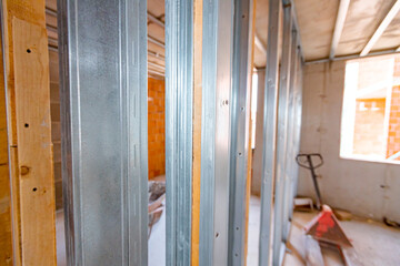 Frame for plasterboard wall, mounted vertical metal and wooden profiles, work in progress of unfinished edifice