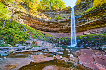 Wall Mural - Fall foliage and layered cliffs by huge waterfall crashing towards lower river