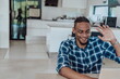 © .shock - African American man in glasses sitting at a table in a modern living room, using a laptop for business video chat, conversation with friends and entertainment