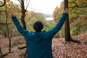 Wall Mural - Female hiker raising arms in forest