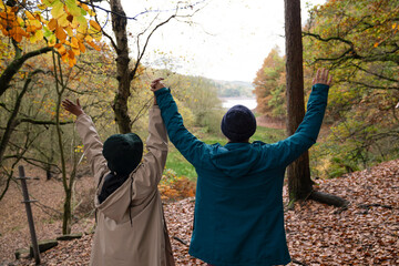 Wall Mural - Female hikers raising hands in forest